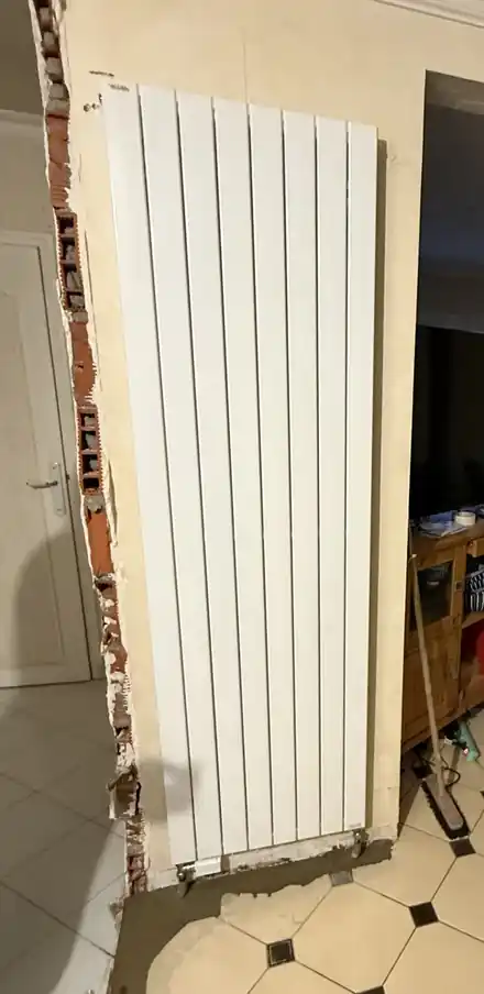 Radiateur vertical neuf raccordé sur une tuyauterie modifiée, travail de W.J. Plomberie