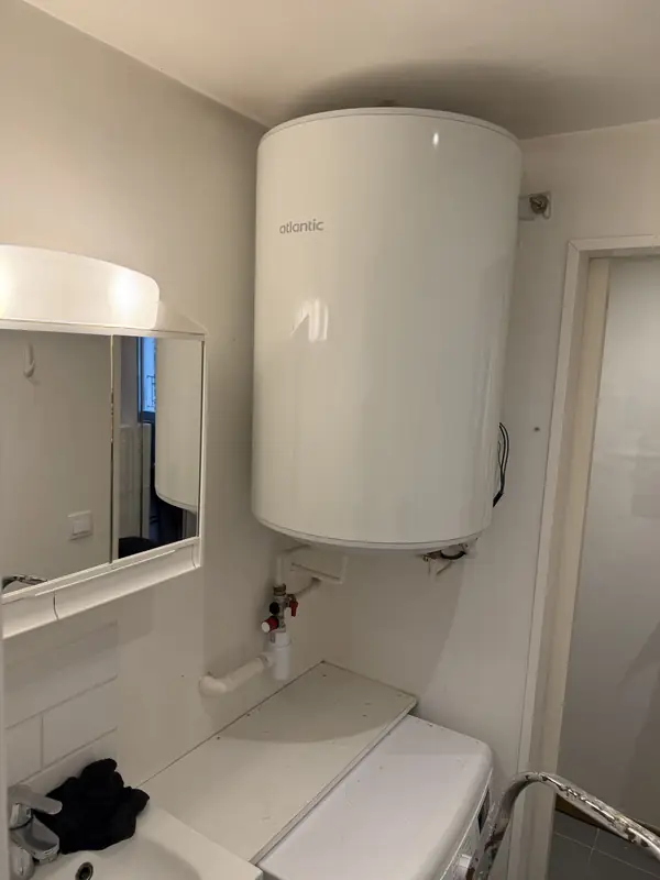 Chauffe-eau électrique neuf posé au mur avec son groupe de sécurité, travail de W.J. Plomberie